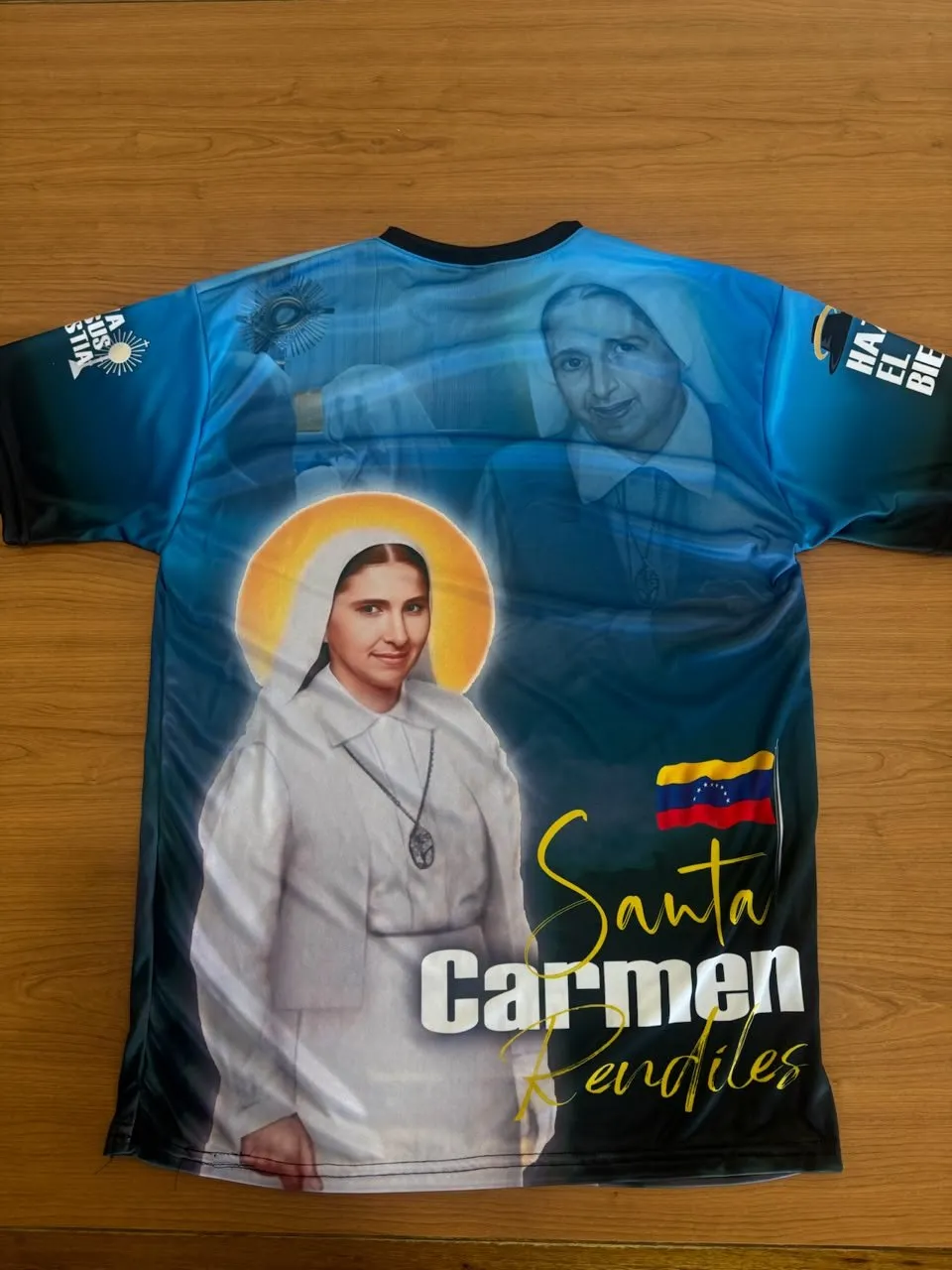Franela celeste con una imagen religiosa y la bandera de Venezuela