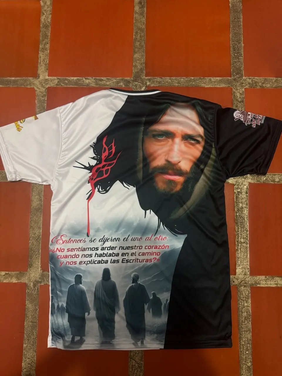 Franela con una imagen religiosa, fotografiada sobre pared de ladrillo